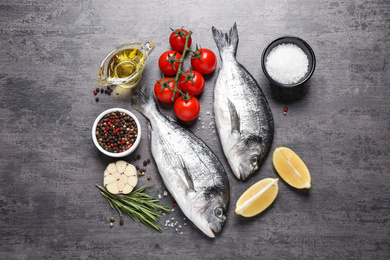 Flat lay composition with raw dorada fish on grey table