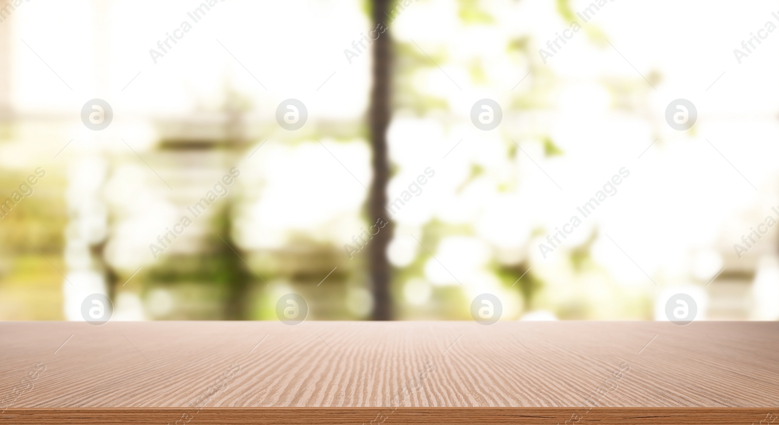 Image of Empty wooden table in front of window. Sunny morning 