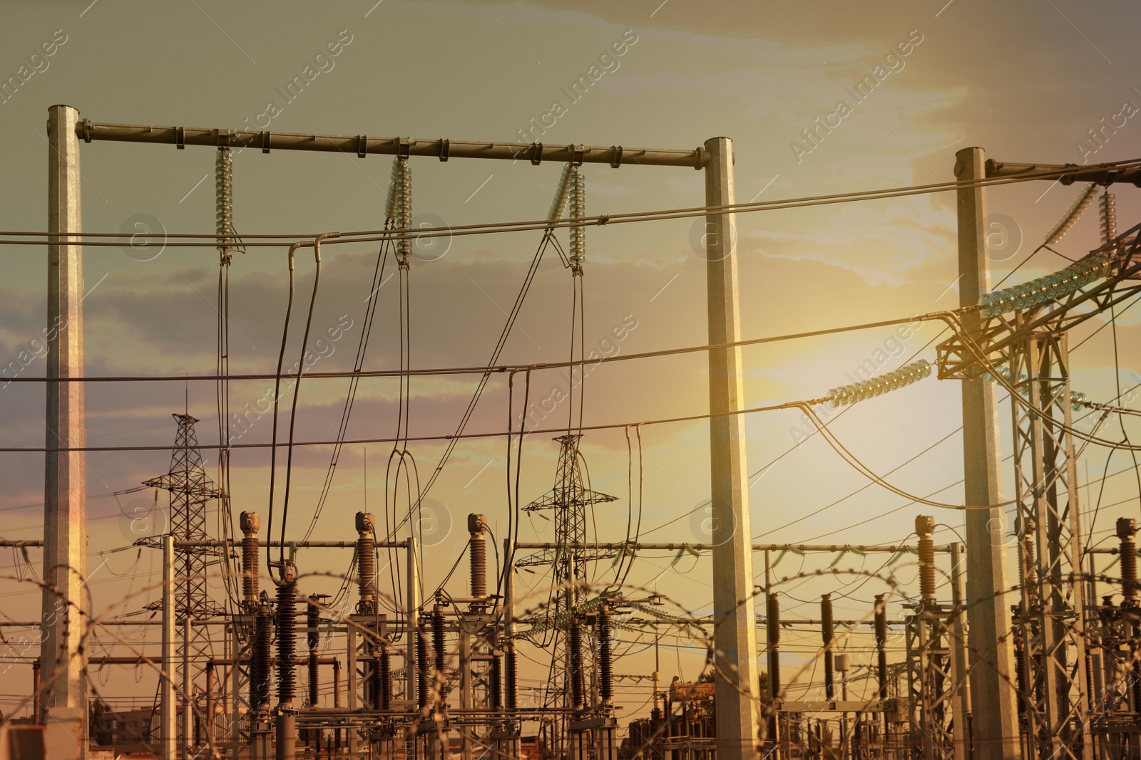 Photo of Modern electrical substation against cloudy sky at sunset