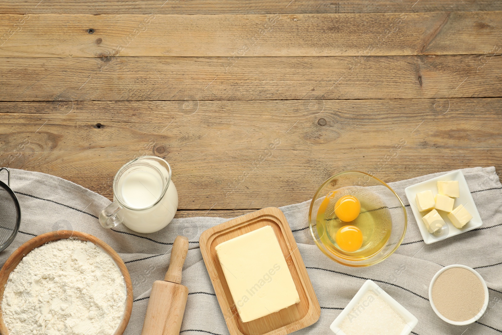 Photo of Flat lay composition with fresh butter and other products on wooden table. Space for text