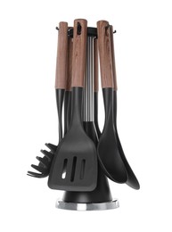 Set of wooden kitchen utensils on stand against white background