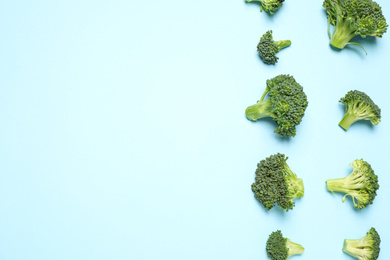 Photo of Fresh tasty broccoli on light blue background, flat lay. Space for text