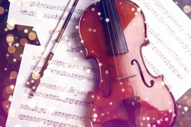 Violin, bow and note sheets on stone table, top view