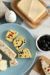 Photo of Different types of tasty butter served on white table, flat lay