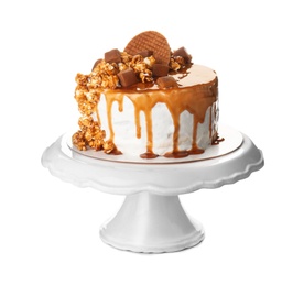 Dessert stand with delicious caramel cake on white background