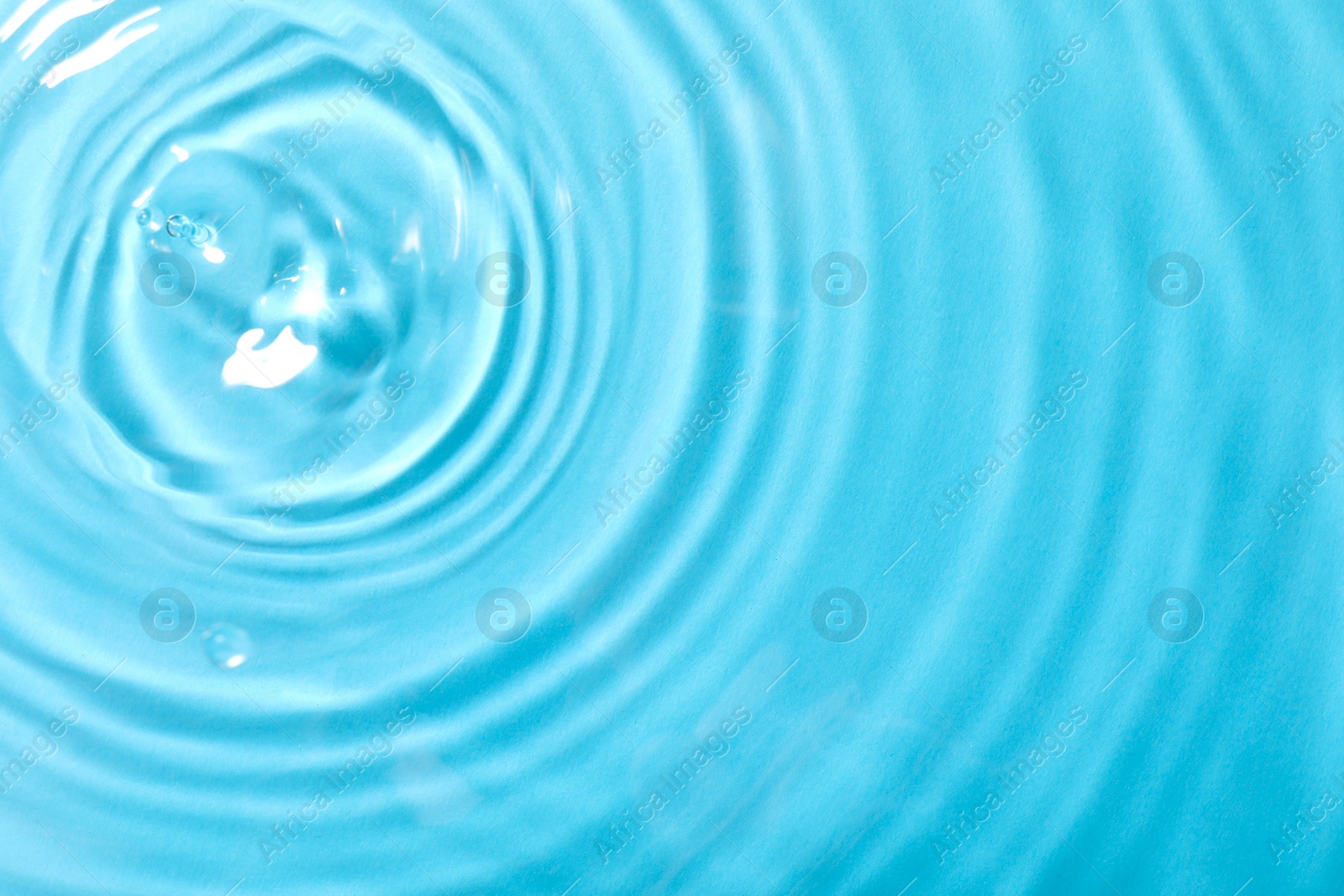 Photo of Closeup view of water with rippled surface on light blue background