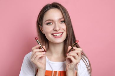 Photo of Beauty blogger with lipsticks on pink background