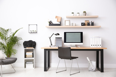 Photo of Modern computer on table in office interior. Stylish workplace