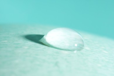Photo of Macro photo of water drop on turquoise background