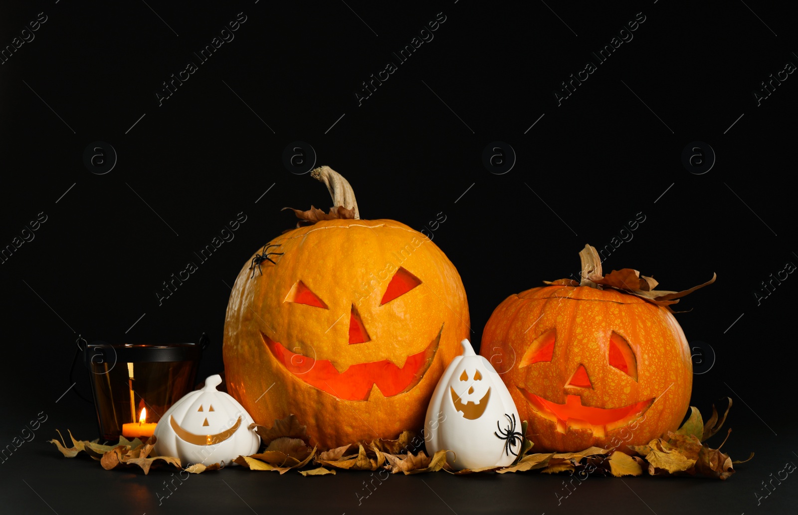 Photo of Composition with pumpkin heads on black background. Jack lantern - traditional Halloween decor