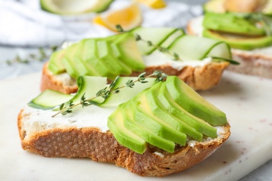 Photo of Tasty sandwiches with avocado and cucumber on table, closeup