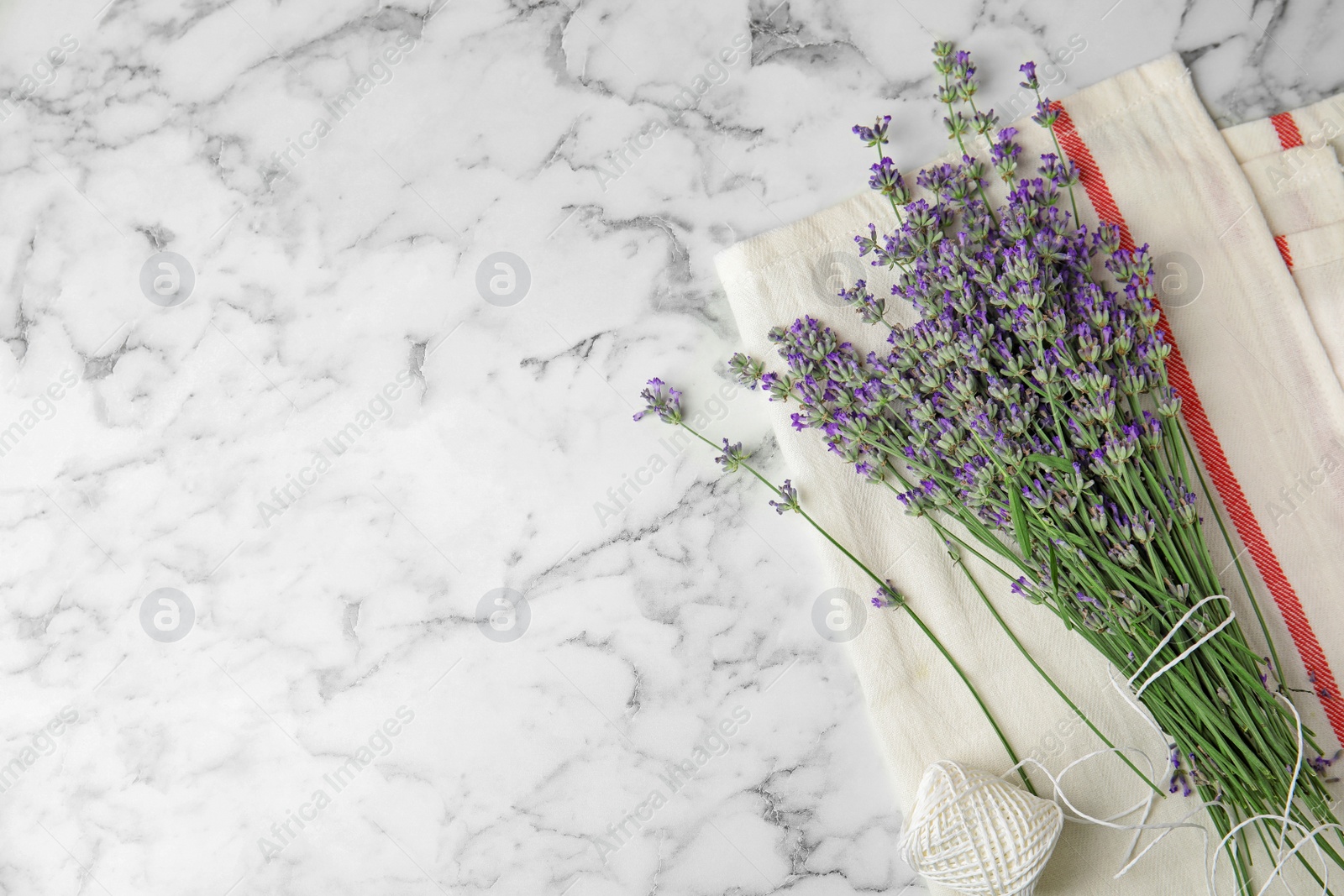 Photo of Beautiful tender lavender flowers on white marble table, top view. Space for text