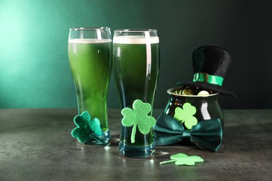 St. Patrick's day celebration. Green beer, leprechaun hat, pot of gold and decorative clover leaves on grey table