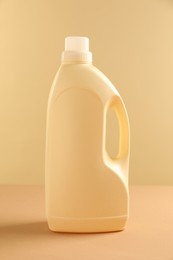 Bottle with detergent on beige background. Cleaning supply