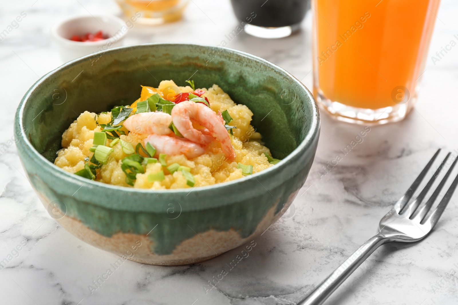 Photo of Bowl with fresh tasty shrimp and grits on table