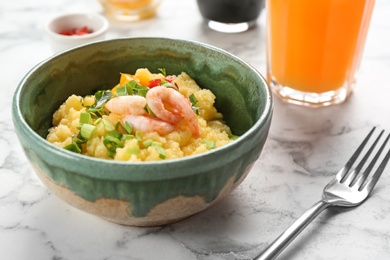 Photo of Bowl with fresh tasty shrimp and grits on table