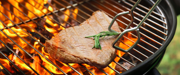 Image of Tasty meat on barbecue grill with fire flames outdoors, closeup. Banner design