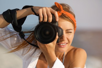 Photographer taking photo with professional camera near sea