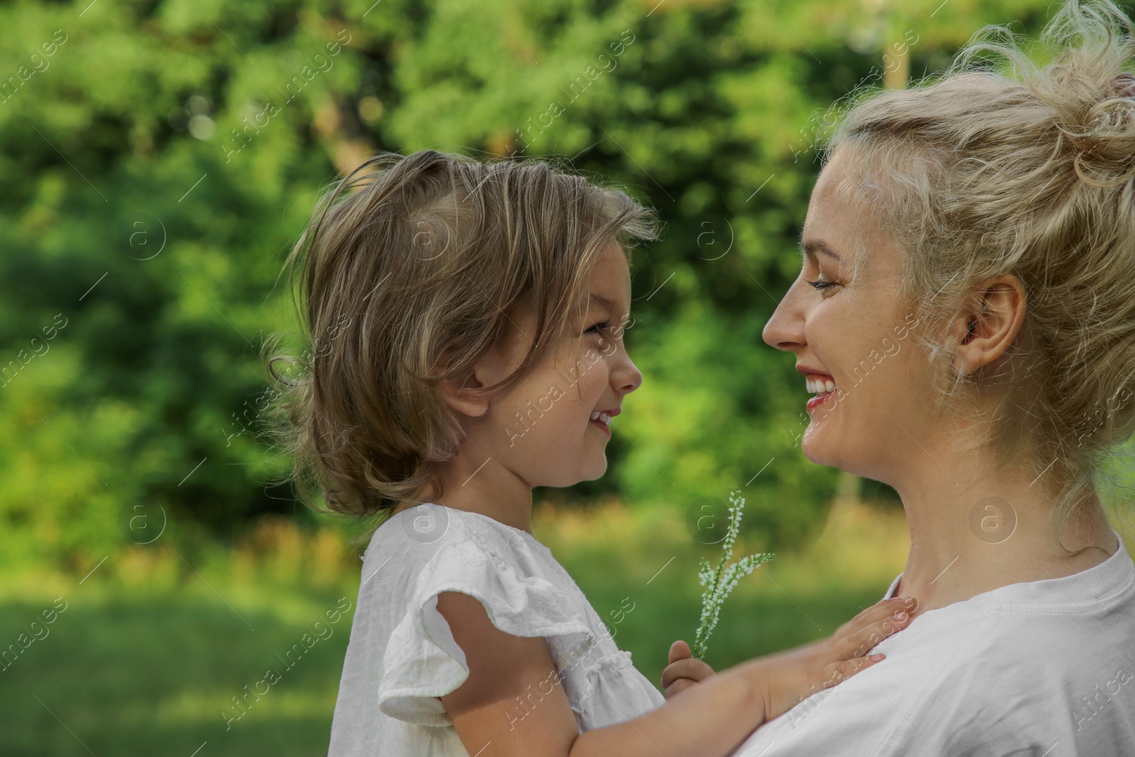 Photo of Happy mother with her cute daughter spending time together outdoors