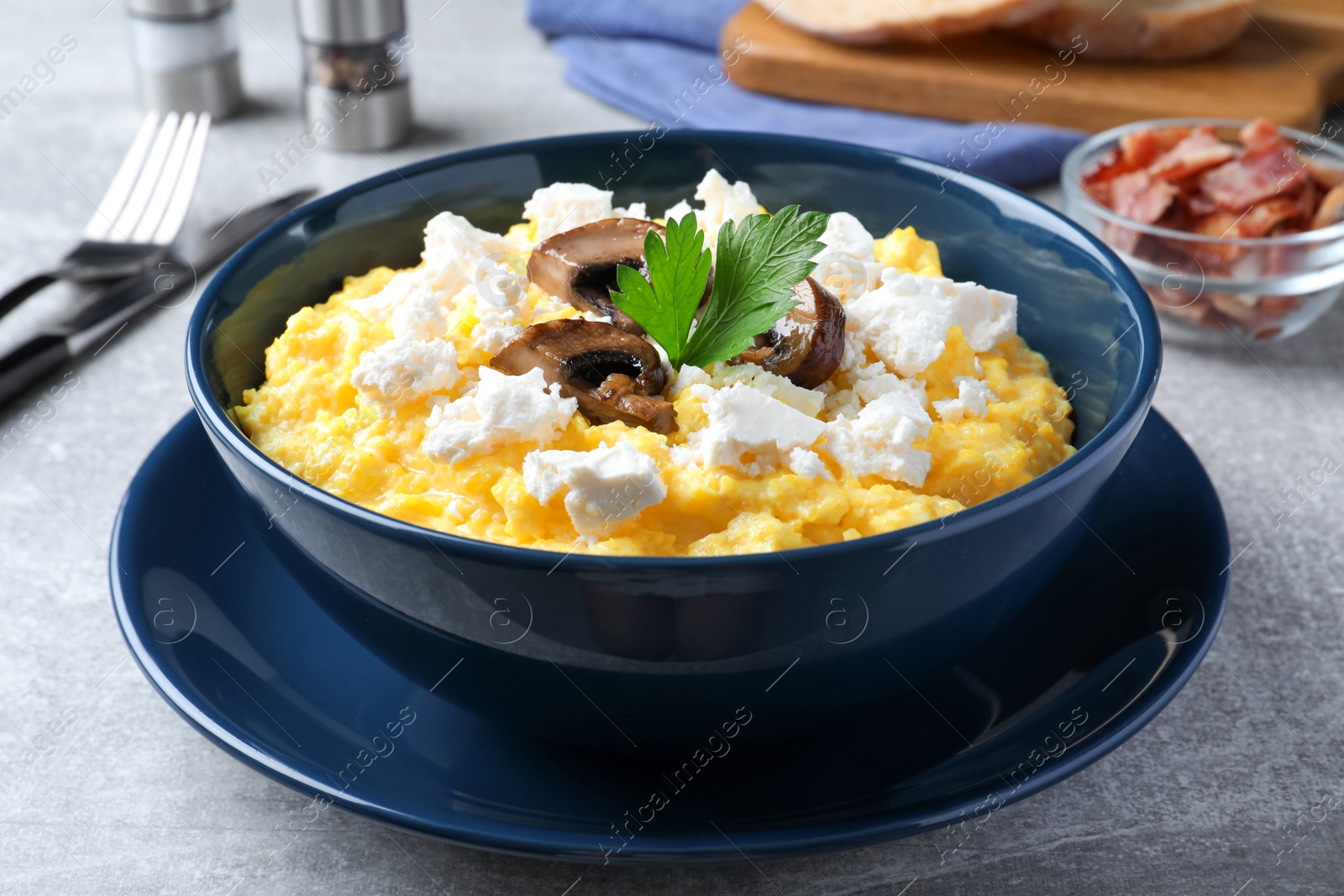 Photo of Tasty banosh served with brynza and mushrooms on grey table, closeup. Traditional Ukrainian dish