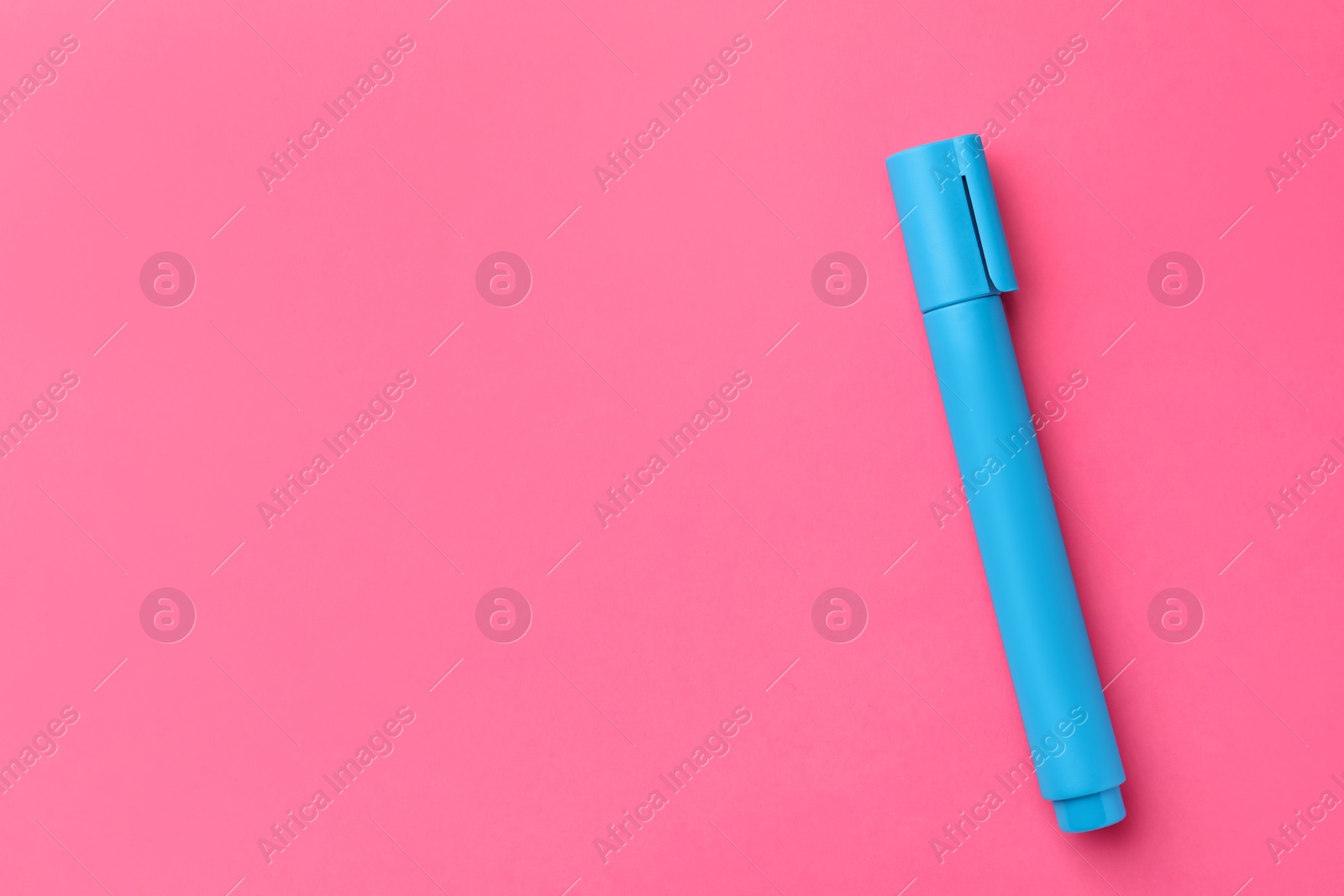 Photo of Bright light blue marker on pink background, top view. Space for text