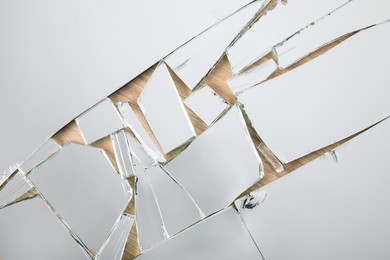 Shards of broken mirror on wooden background, top view