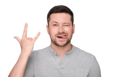 Photo of Happy man showing his tongue and rock gesture on white background