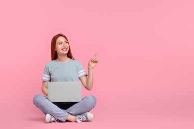 Photo of Smiling young woman with laptop on pink background, space for text