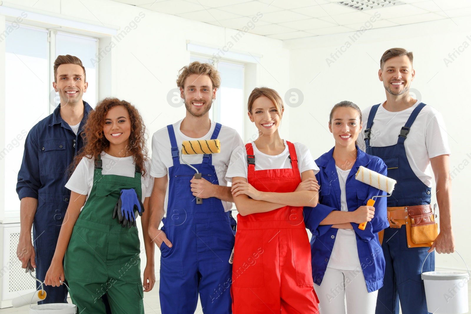 Photo of Team of professional painters with tools indoors