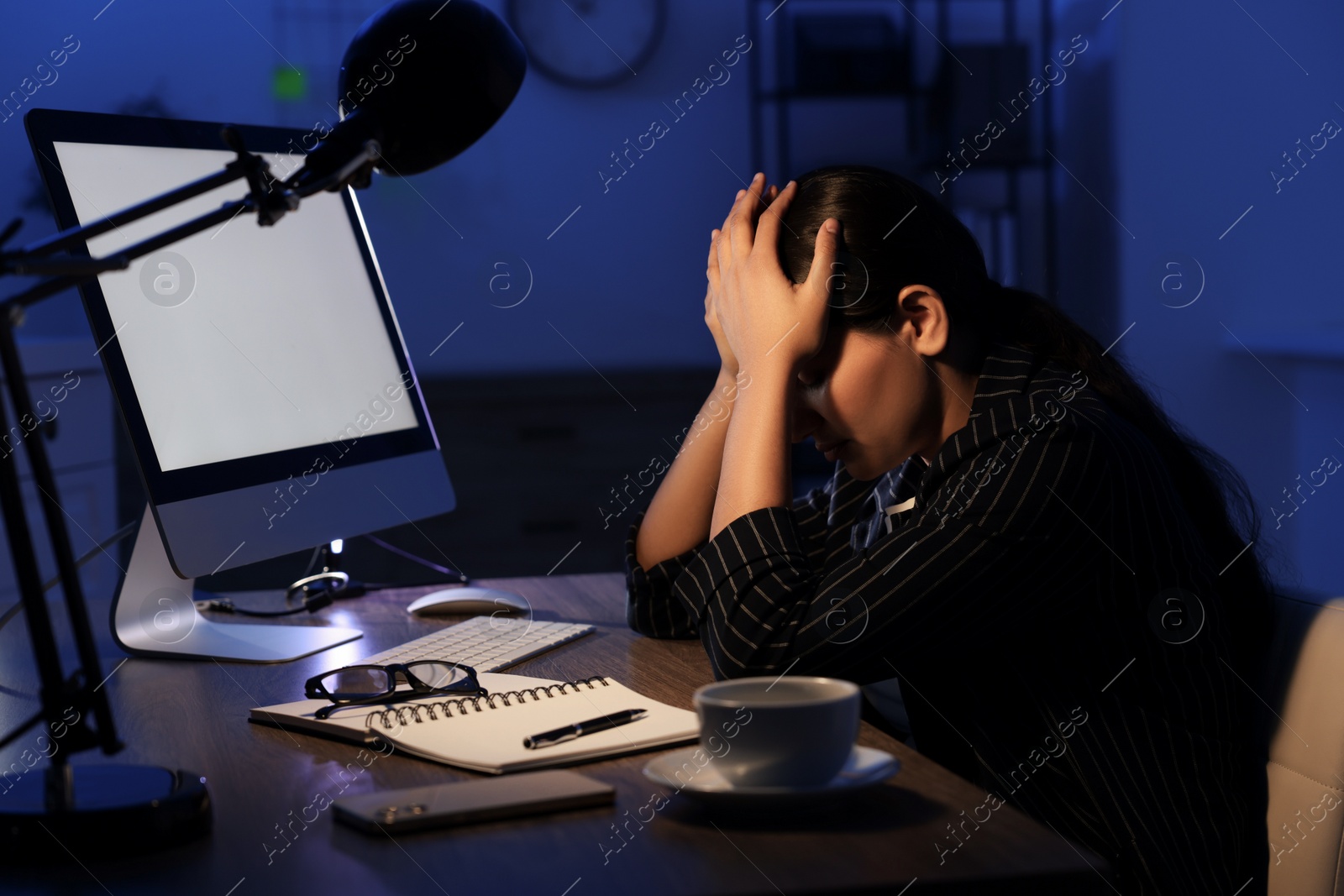 Photo of Tired overworked businesswoman at night in office