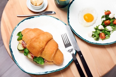 Tasty croissant sandwich served for breakfast on table