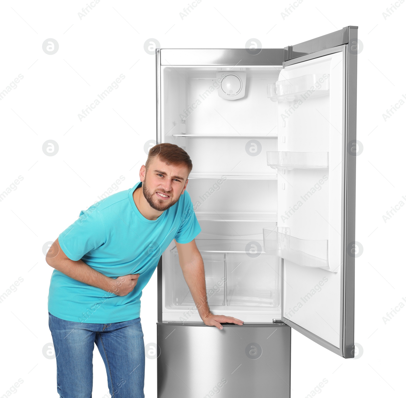 Photo of Hungry man near empty refrigerator on white background