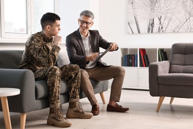 Professional psychotherapist working with military man in office