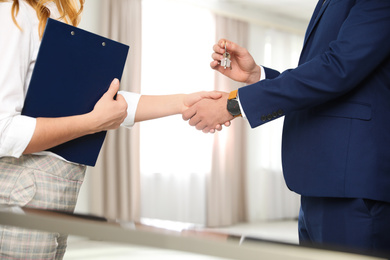 Photo of Real estate agent shaking hands with client in office, closeup