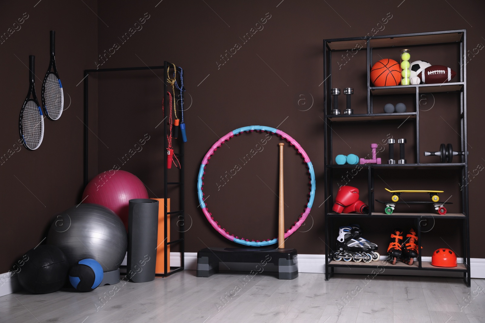 Photo of Many different sports equipment in room with brown walls