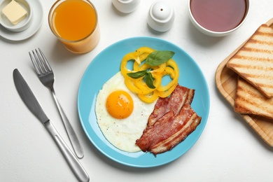 Photo of Tasty breakfast with fried egg served on light table, flat lay