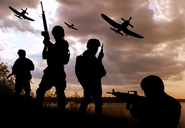 Silhouettes of soldiers with assault rifles and military airplanes patrolling outdoors