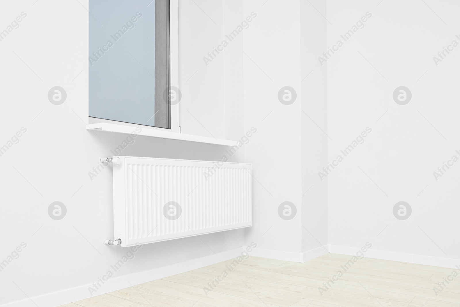 Photo of New empty office room with white walls, radiator and clean window. Interior design