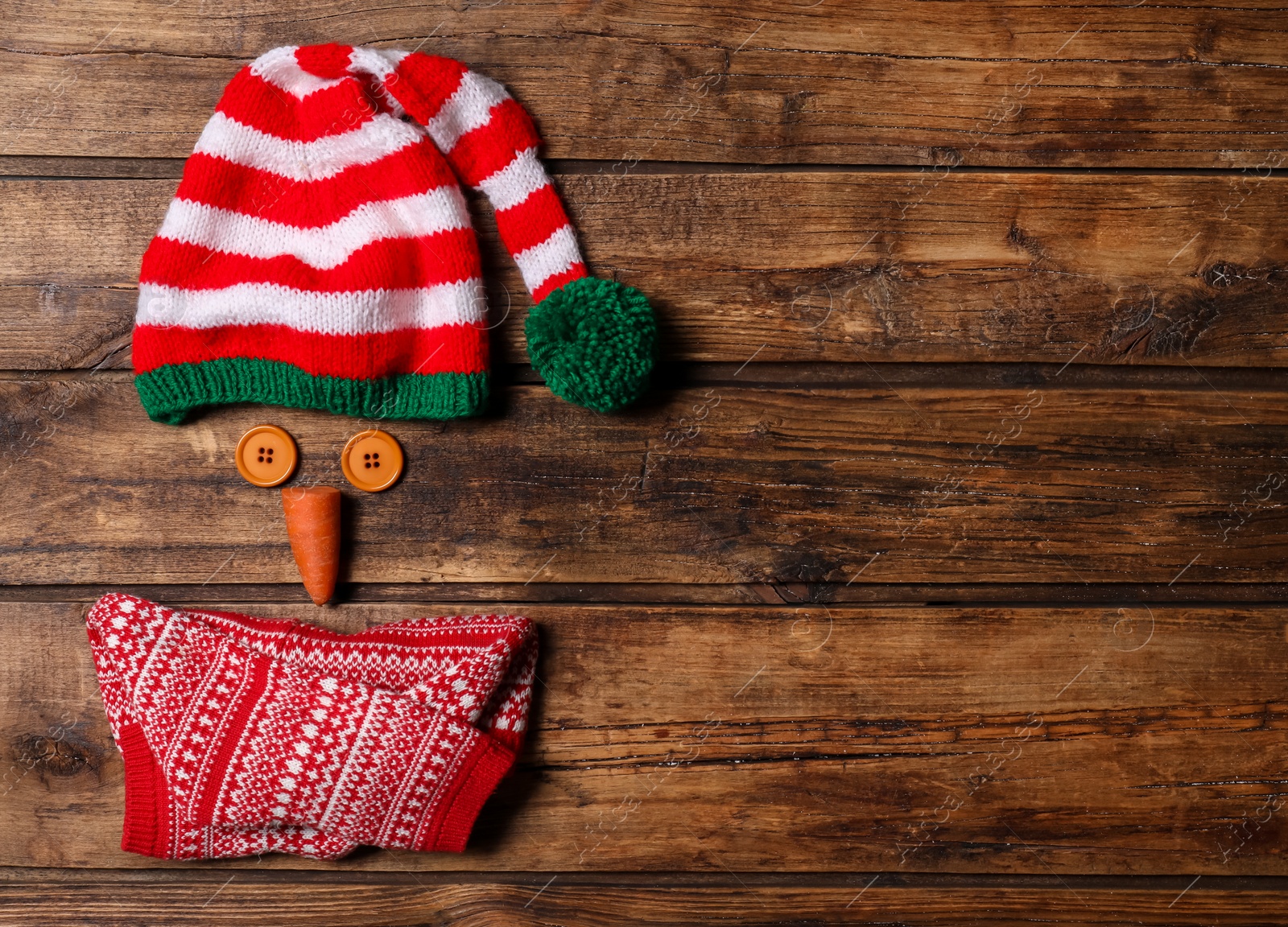 Photo of Funny snowman made with different elements on wooden background, flat lay. Space for text