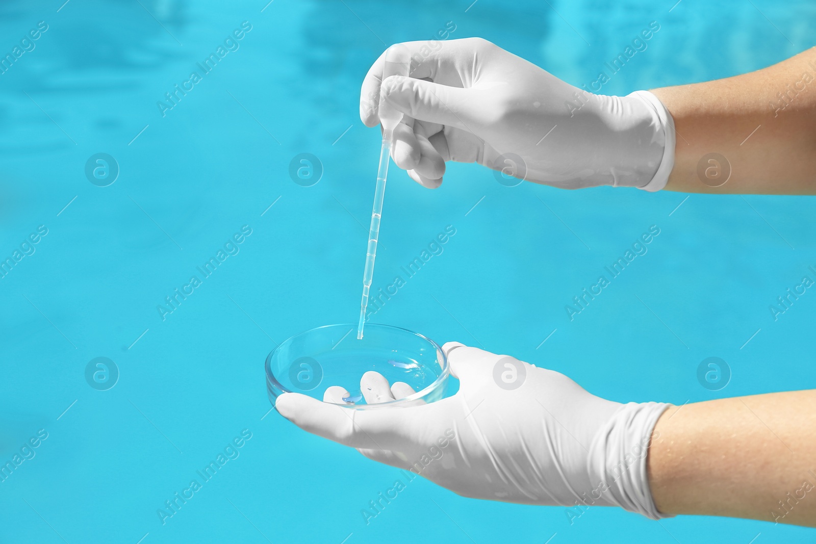 Photo of Woman dripping sample of swimming pool water into Petri dish to check PH level outdoors, closeup