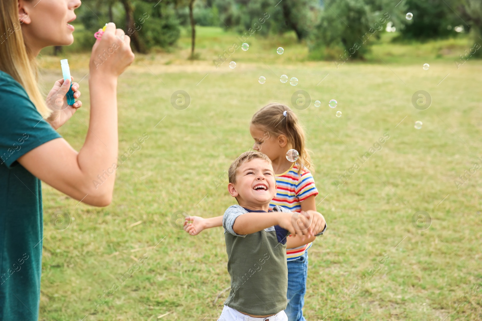 Photo of Woman playing with her children outdoors. Happy family