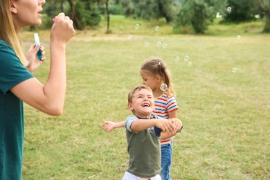 Photo of Woman playing with her children outdoors. Happy family