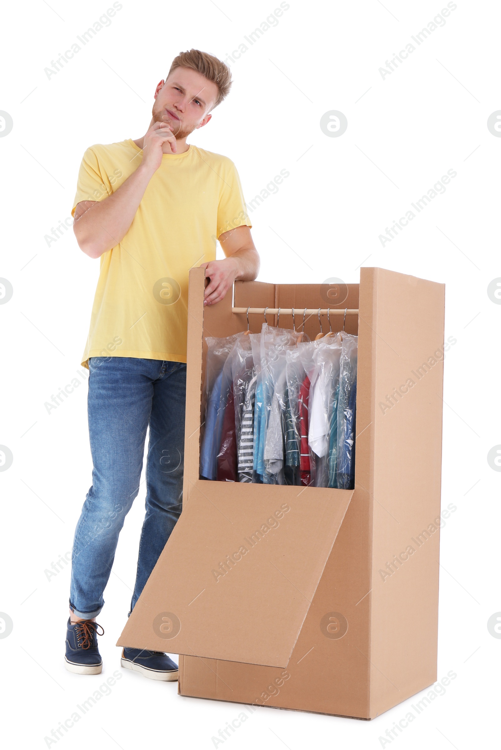 Photo of Young emotional man near wardrobe box on white background