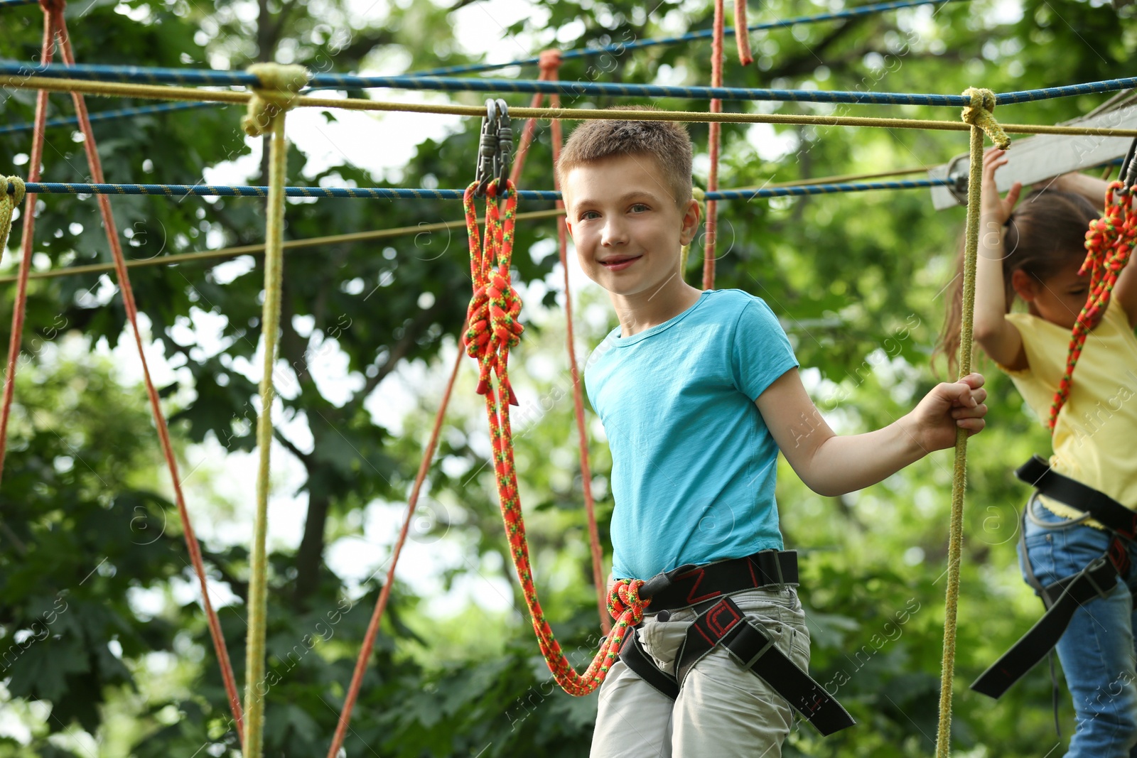 Photo of Little boy climbing in adventure park. Summer camp