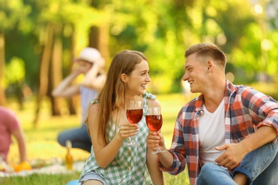 Young couple enjoying picnic in park on summer day