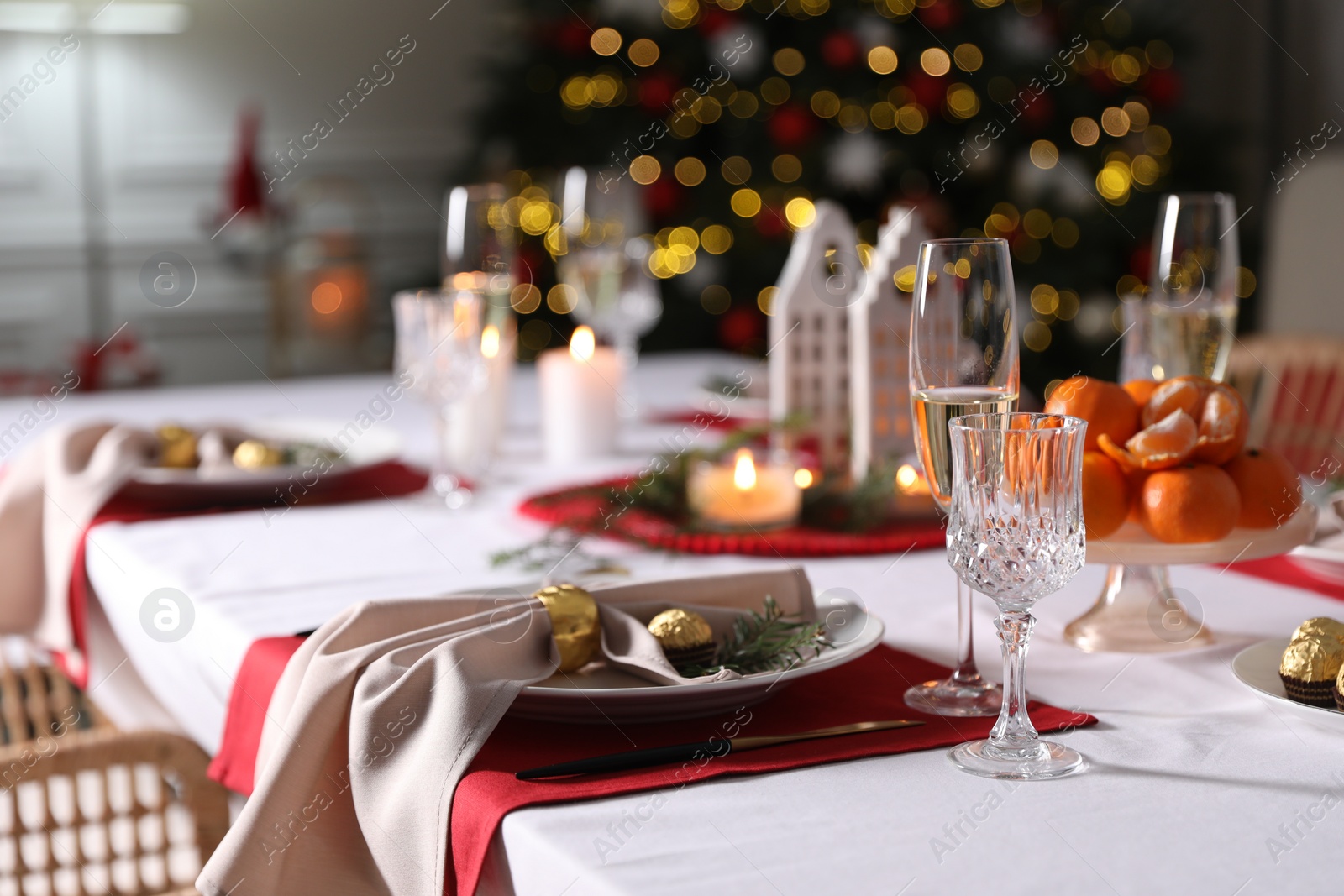 Photo of Christmas table setting with beautiful napkin, cutlery and dishware indoors