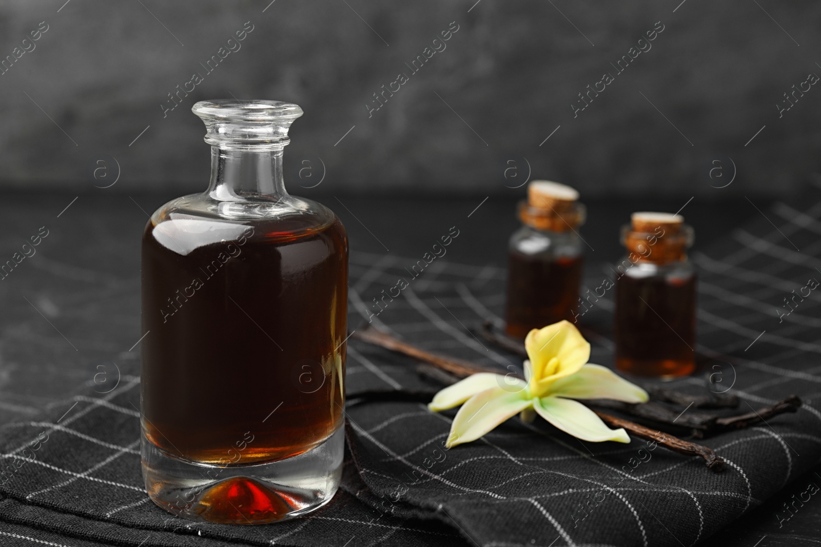 Photo of Aromatic homemade vanilla extract on table, closeup. Space for text