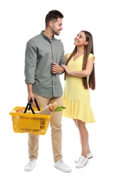 Young couple with shopping basket full of products isolated on white