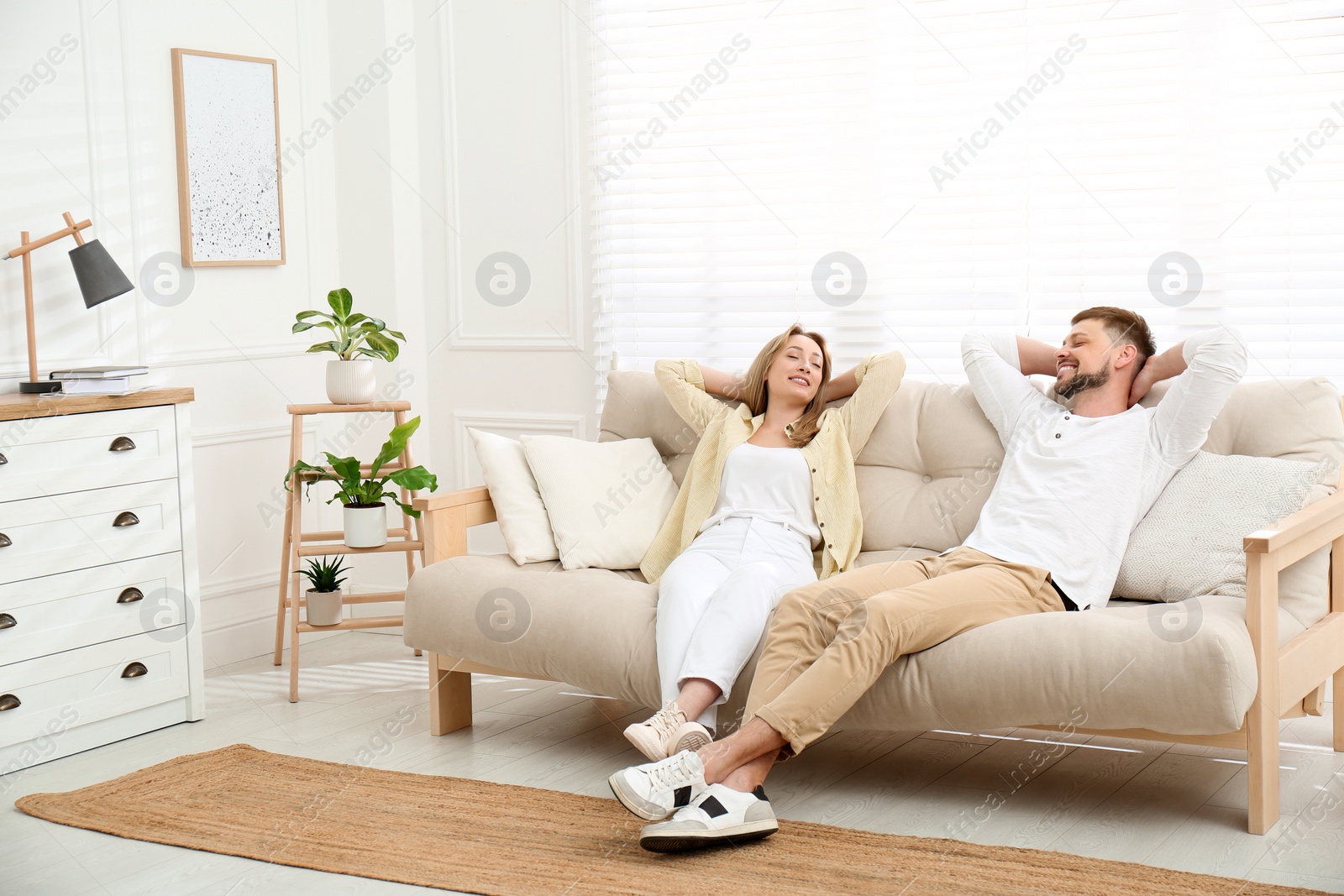 Photo of Couple relaxing on sofa in living room