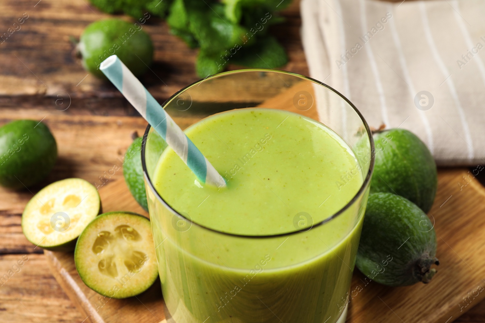 Photo of Fresh feijoa smoothie and fresh fruits on wooden table, closeup